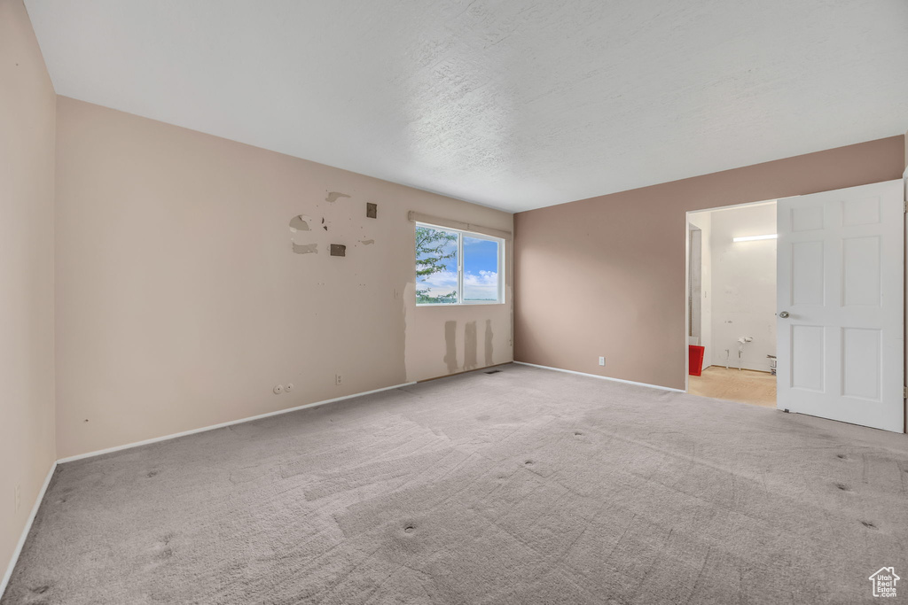 Carpeted spare room featuring baseboards