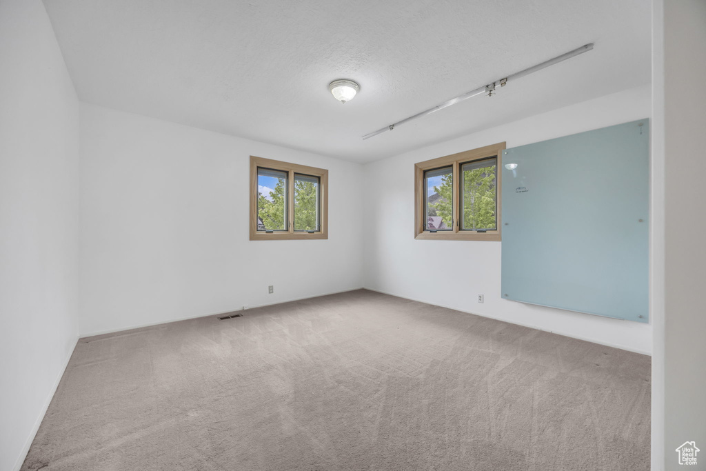 Empty room featuring carpet and a textured ceiling