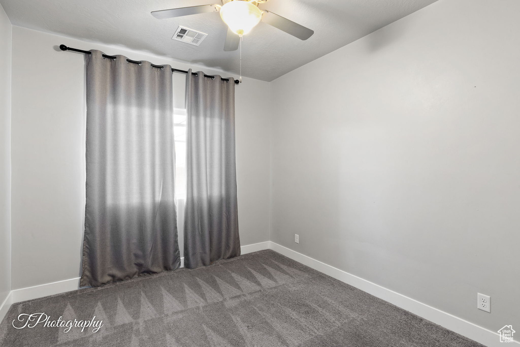 Empty room featuring baseboards, ceiling fan, and carpet flooring