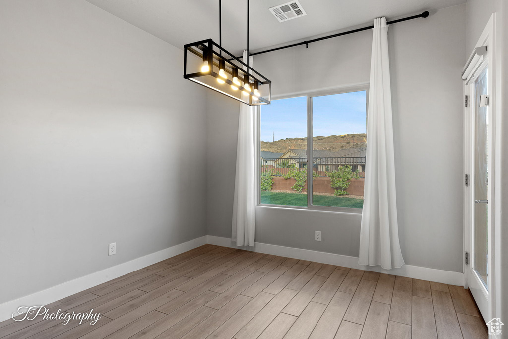 Unfurnished dining area with light wood-style flooring and baseboards