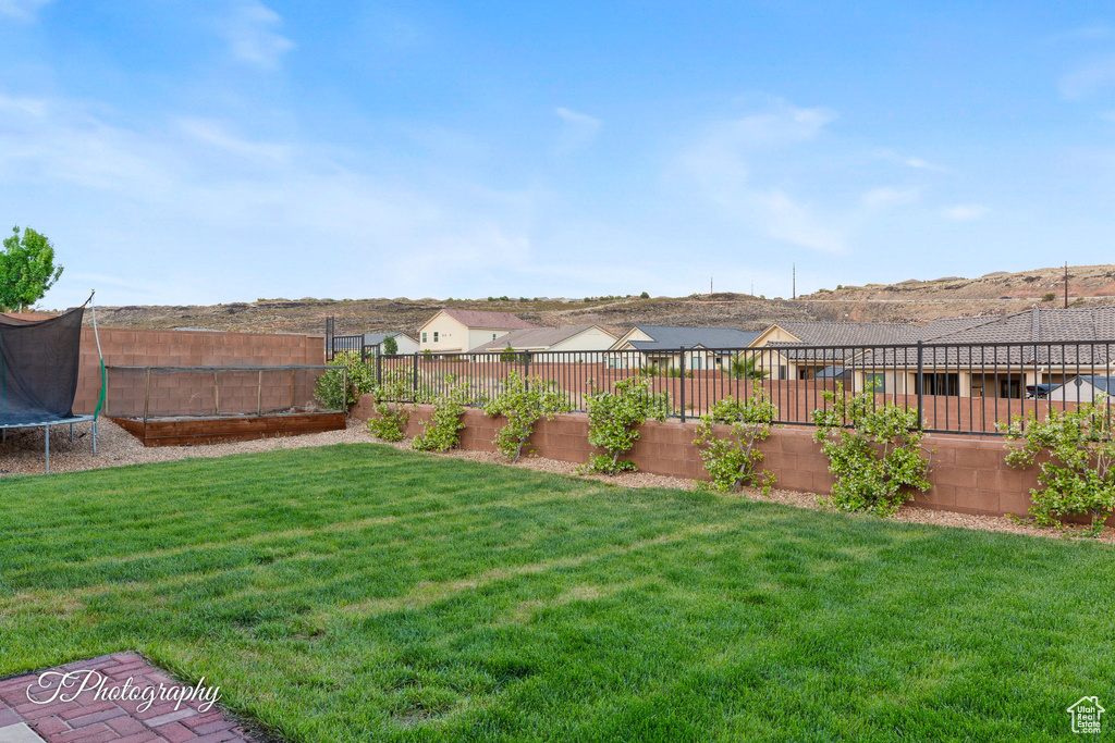 View of yard with a trampoline and a residential view