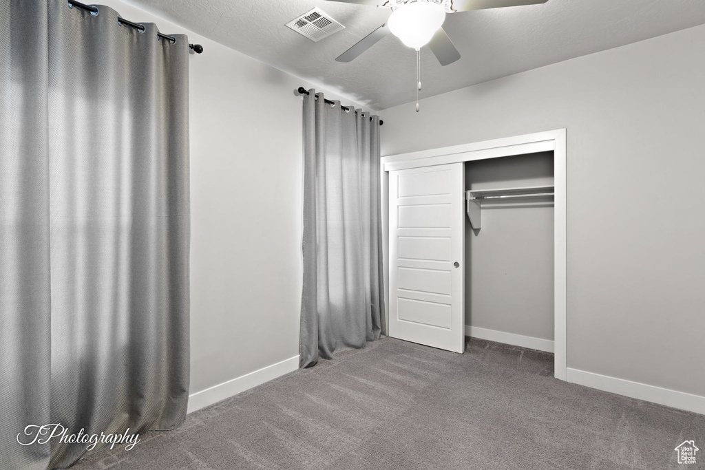Unfurnished bedroom with carpet, baseboards, a closet, and ceiling fan