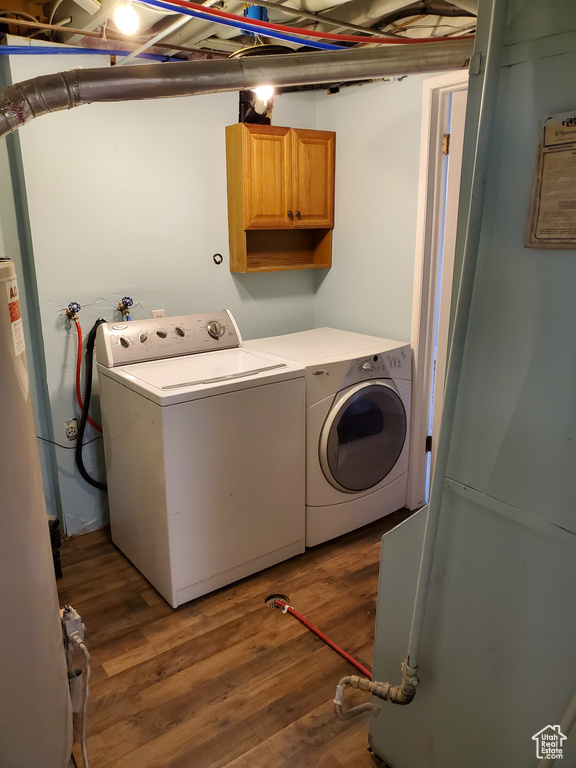 Laundry area with washer and clothes dryer, wood finished floors, and cabinet space