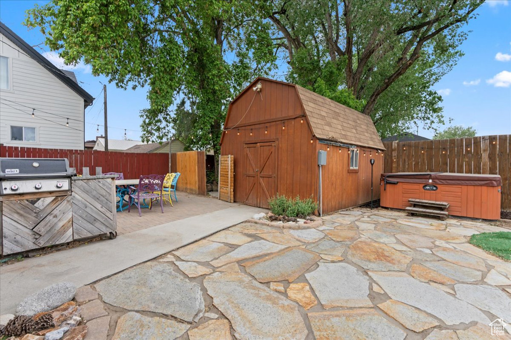View of patio / terrace with a hot tub, a grill, outdoor dining space, and a fenced backyard