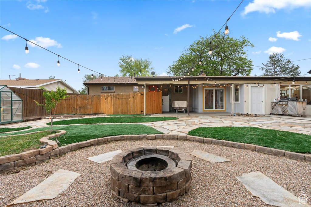Back of house with an outdoor fire pit and a patio area