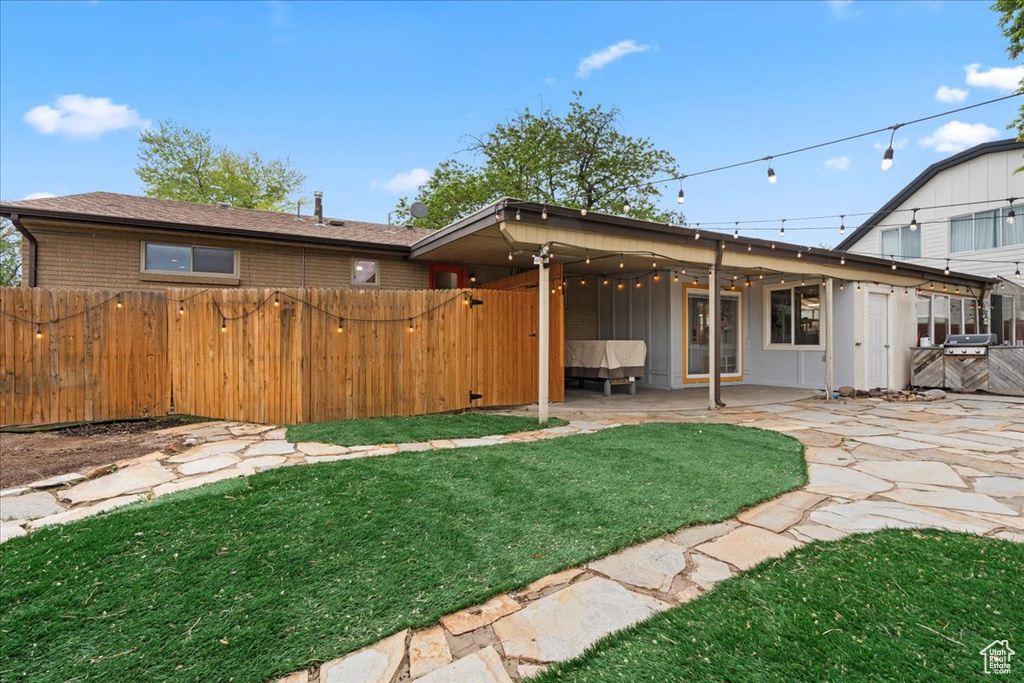 Rear view of property featuring a patio area, a gate, and brick siding