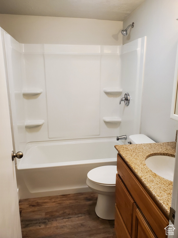 Full bath featuring toilet, wood finished floors, vanity, and shower / washtub combination