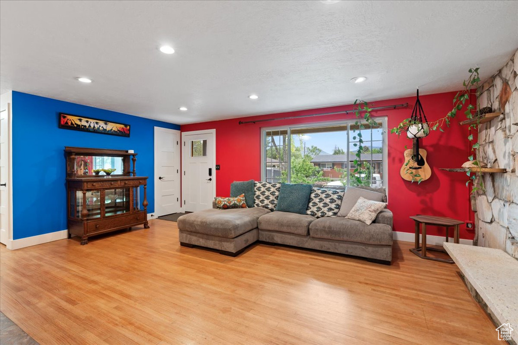 Living room with wood finished floors, baseboards, and recessed lighting