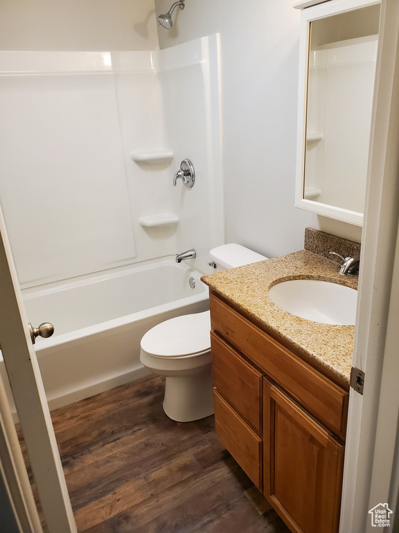 Bathroom featuring toilet, wood finished floors, bathing tub / shower combination, and vanity