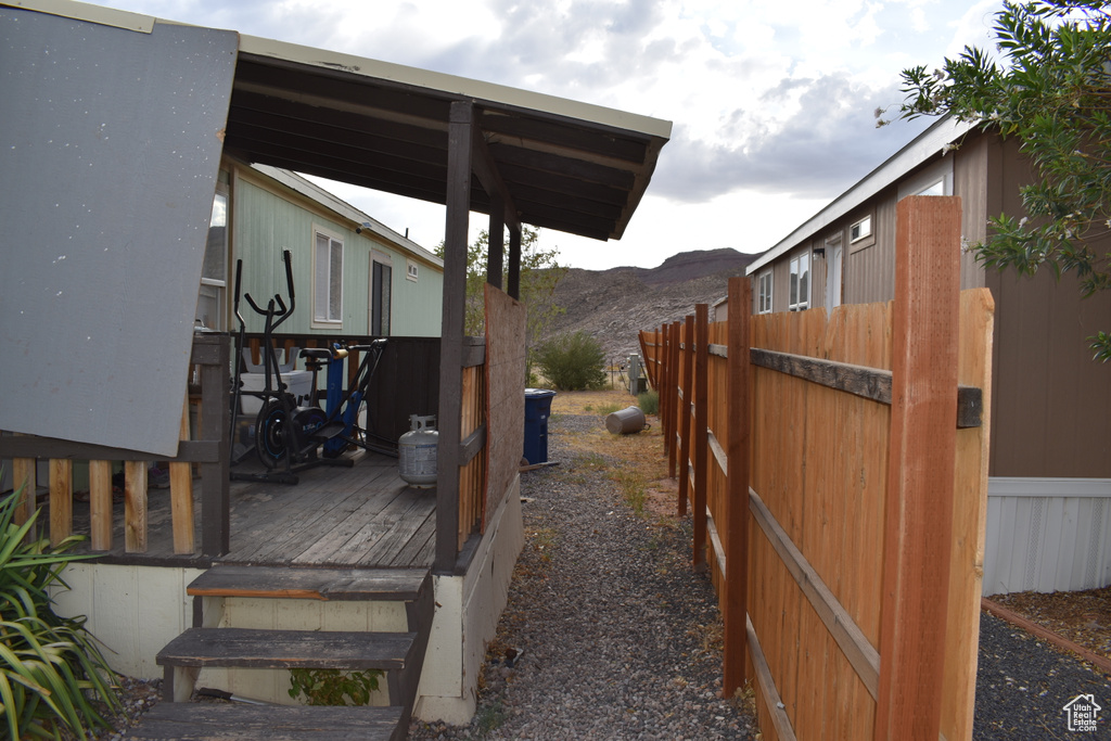 View of home's exterior with a deck with mountain view and fence