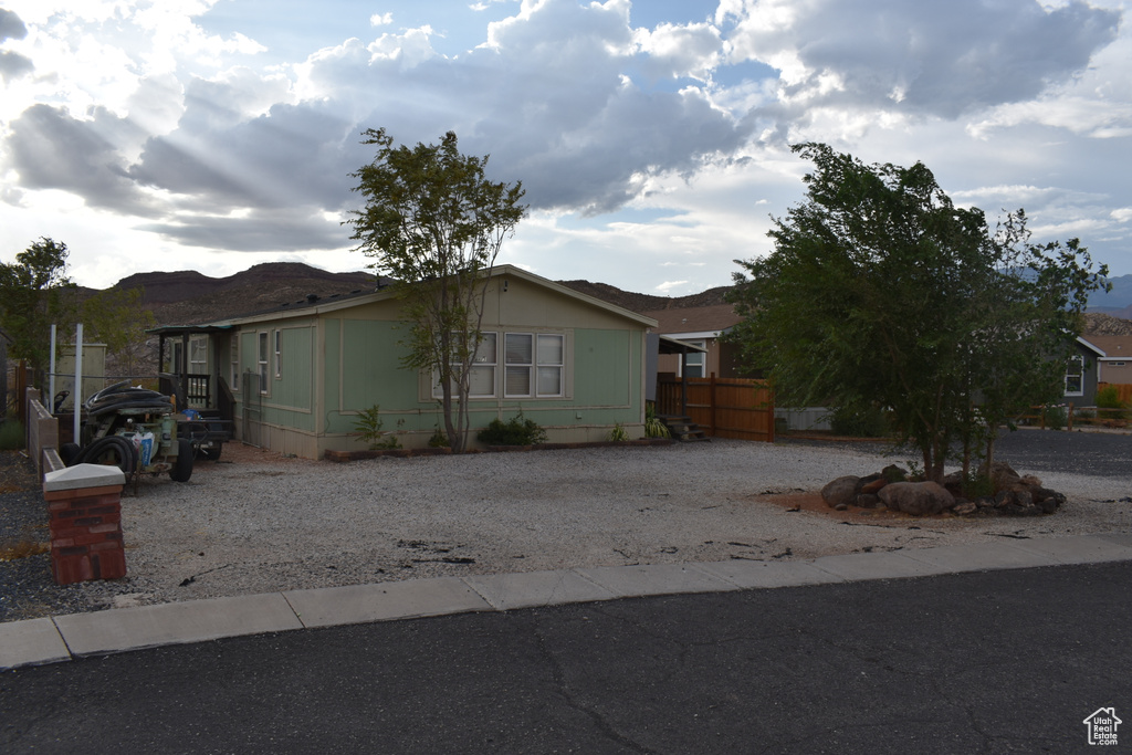 View of front facade with gravel driveway and a mountain view