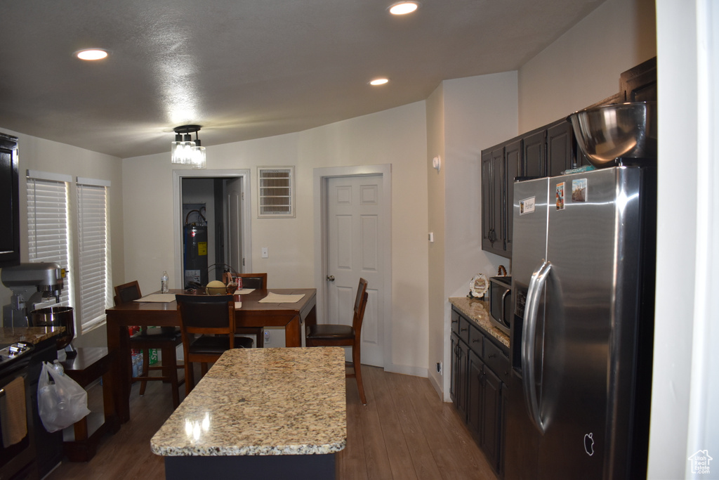Dining area featuring dark wood-style floors, recessed lighting, and electric water heater