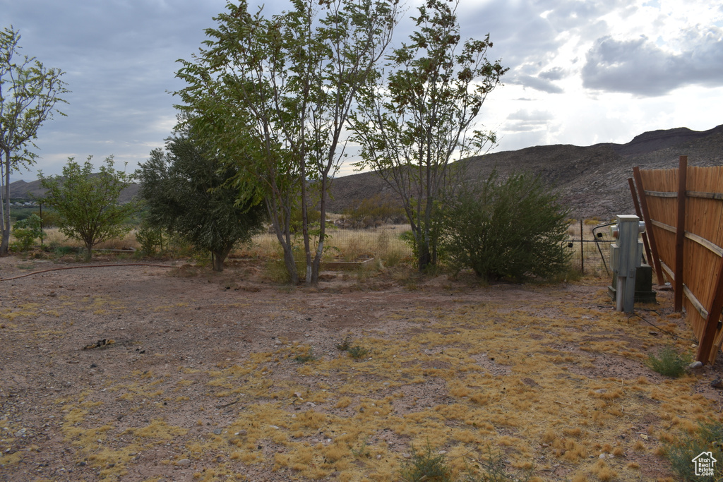 View of yard with a mountain view and fence