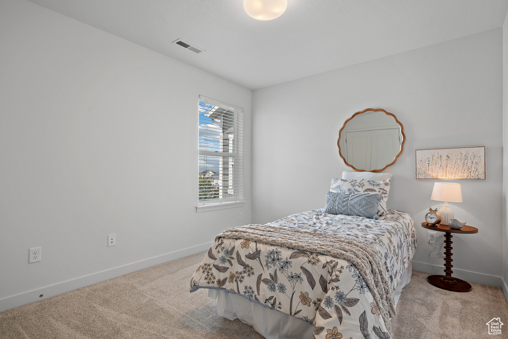Bedroom featuring carpet and baseboards