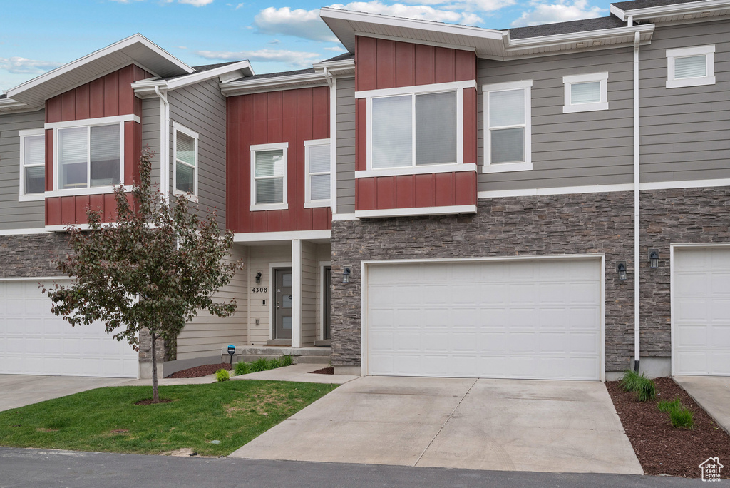 Multi unit property featuring board and batten siding, stone siding, and an attached garage