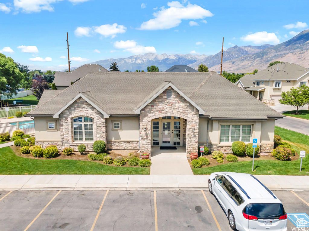 View of front of property featuring stone siding, stucco siding, and french doors