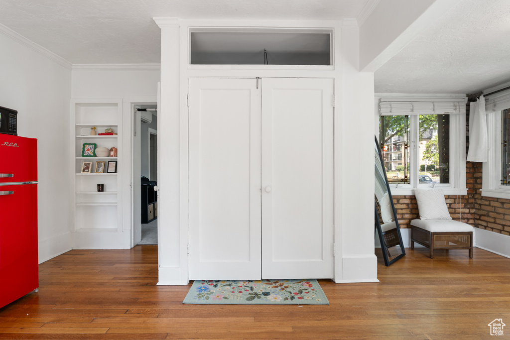 Entrance foyer with hardwood / wood-style flooring, crown molding, and baseboards