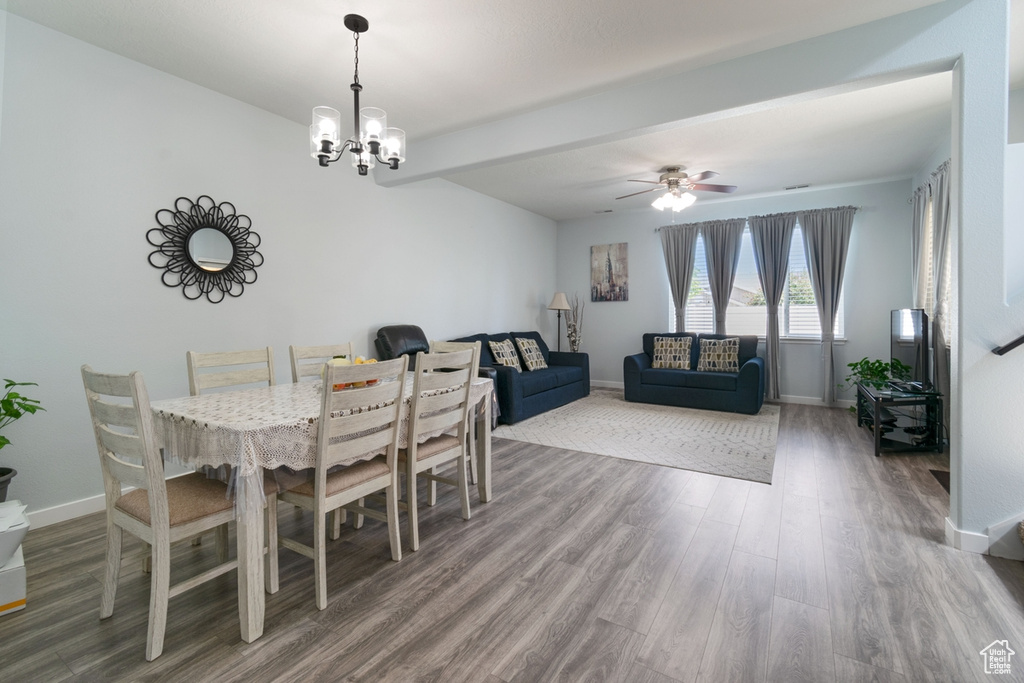 Dining space with wood finished floors, baseboards, beamed ceiling, a chandelier, and a ceiling fan