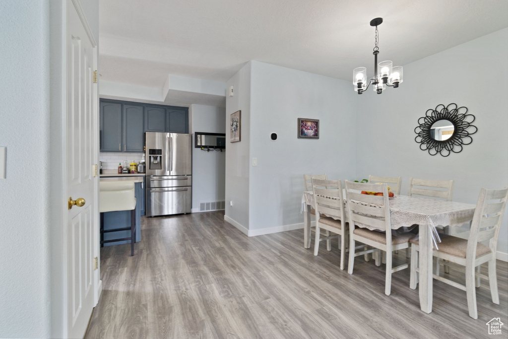 Dining space featuring wood finished floors, baseboards, and a chandelier