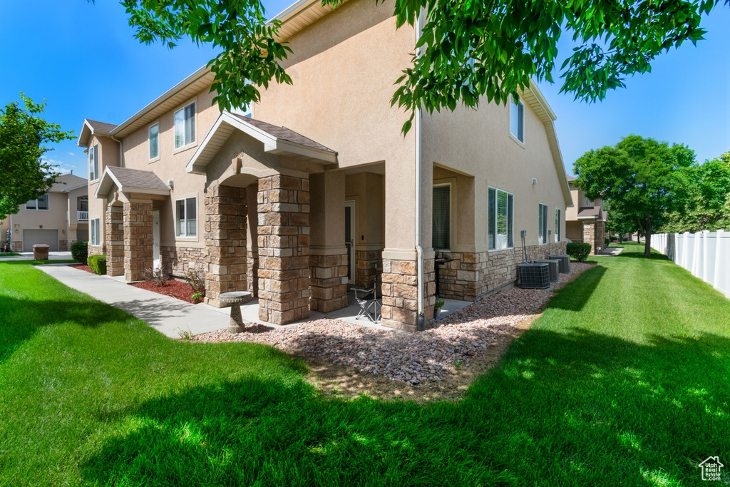 View of side of property featuring stone siding, stucco siding, and central air condition unit