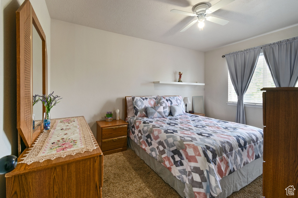 Carpeted bedroom featuring ceiling fan