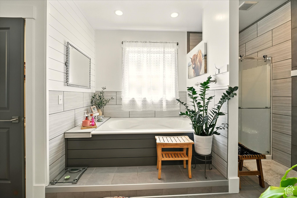Bathroom with a garden tub, tile patterned flooring, tile walls, a stall shower, and recessed lighting