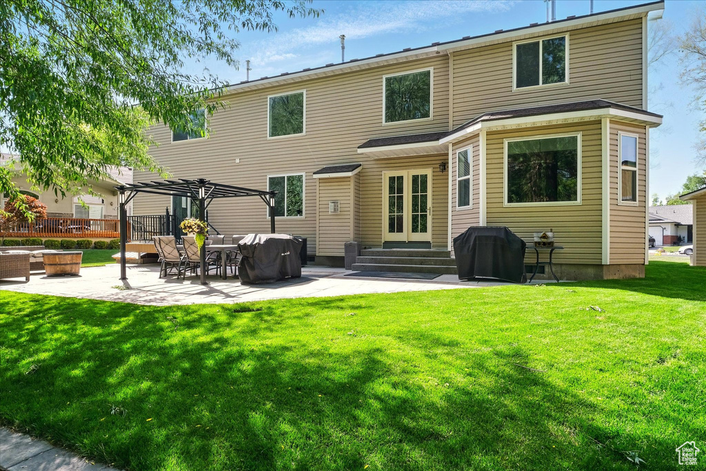 Rear view of house with a patio area, a yard, entry steps, and a pergola