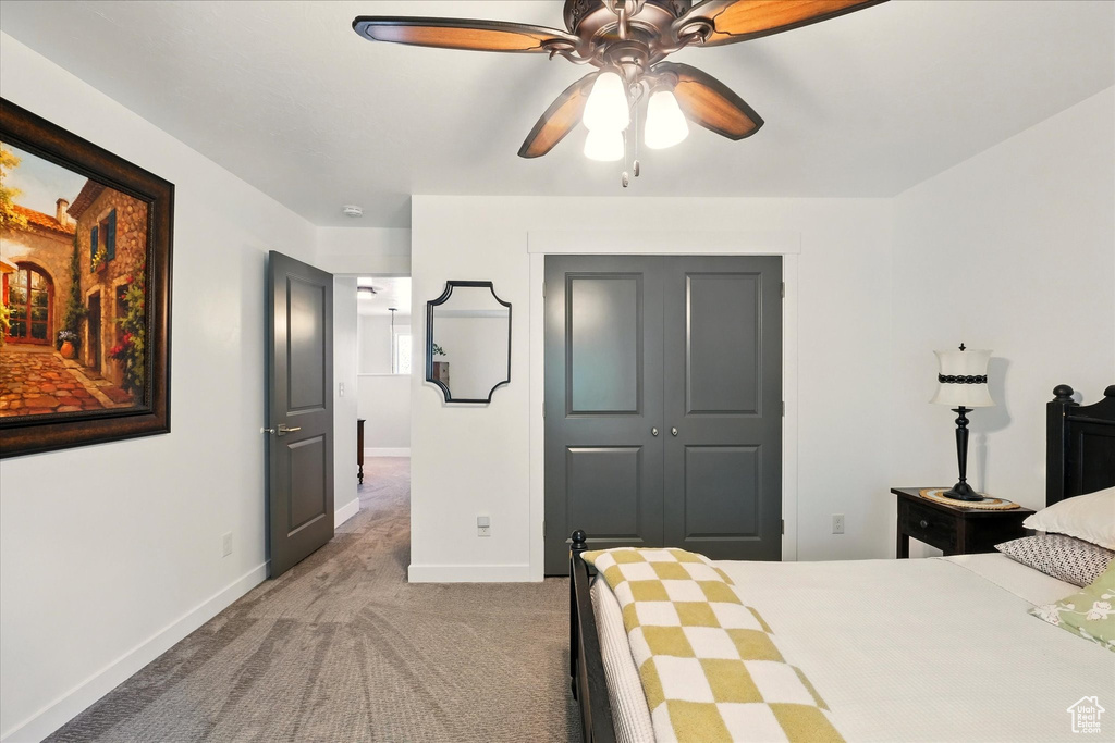 Bedroom with carpet, baseboards, a closet, and a ceiling fan