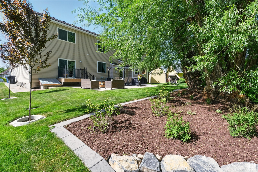 Rear view of property with a lawn and a patio area