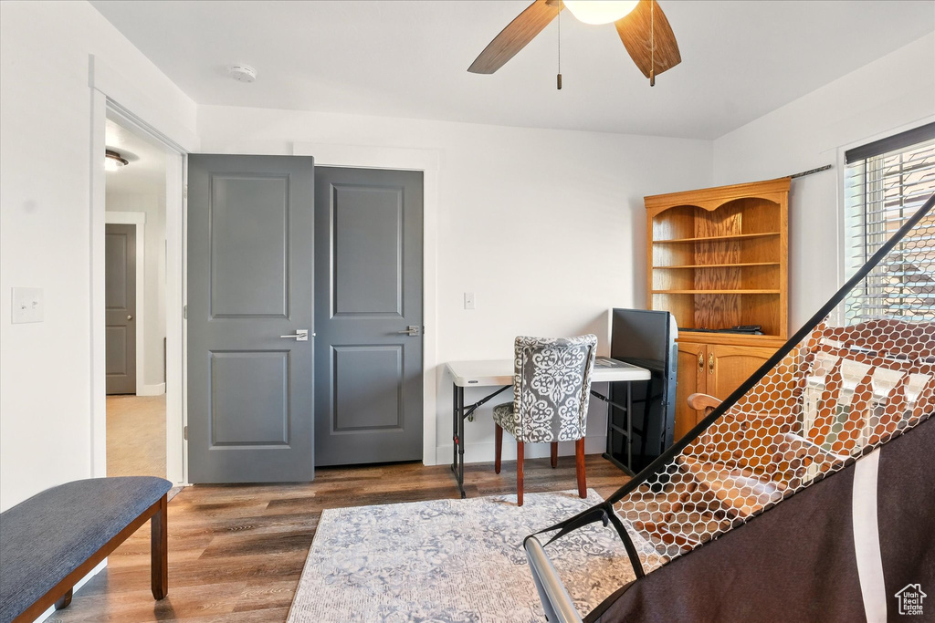 Living area with a ceiling fan, wood finished floors, and an office area