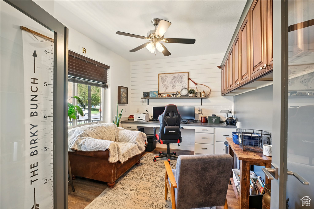 Office featuring wood finished floors, a ceiling fan, and built in study area
