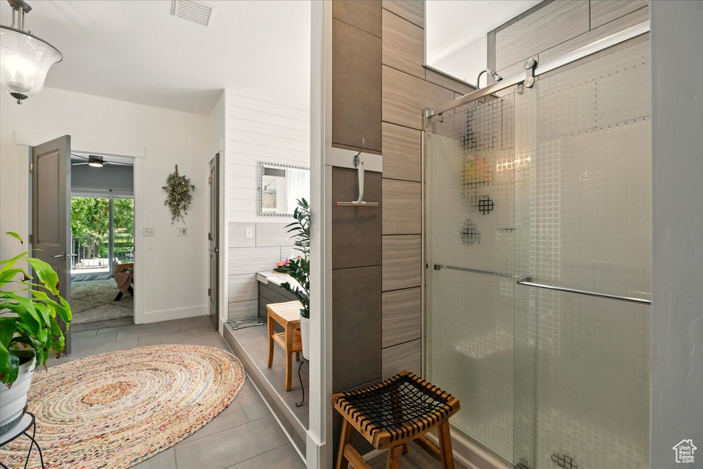 Bathroom with a shower stall, tile patterned floors, and ceiling fan