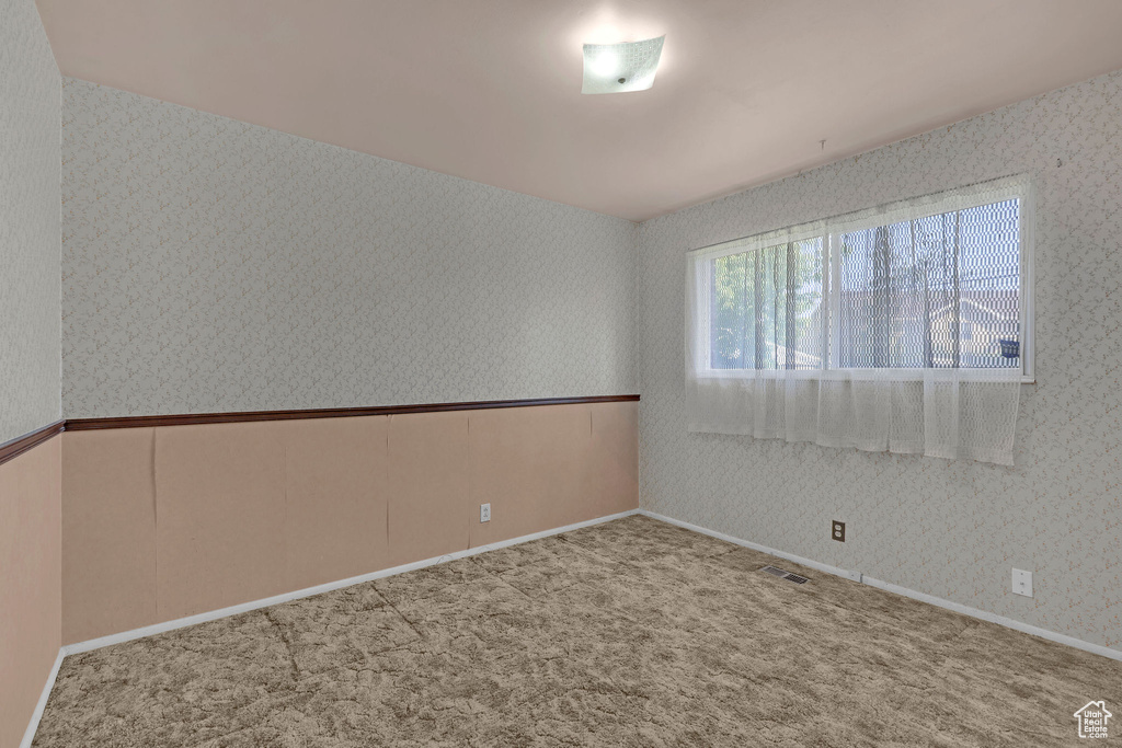 Carpeted empty room featuring wallpapered walls