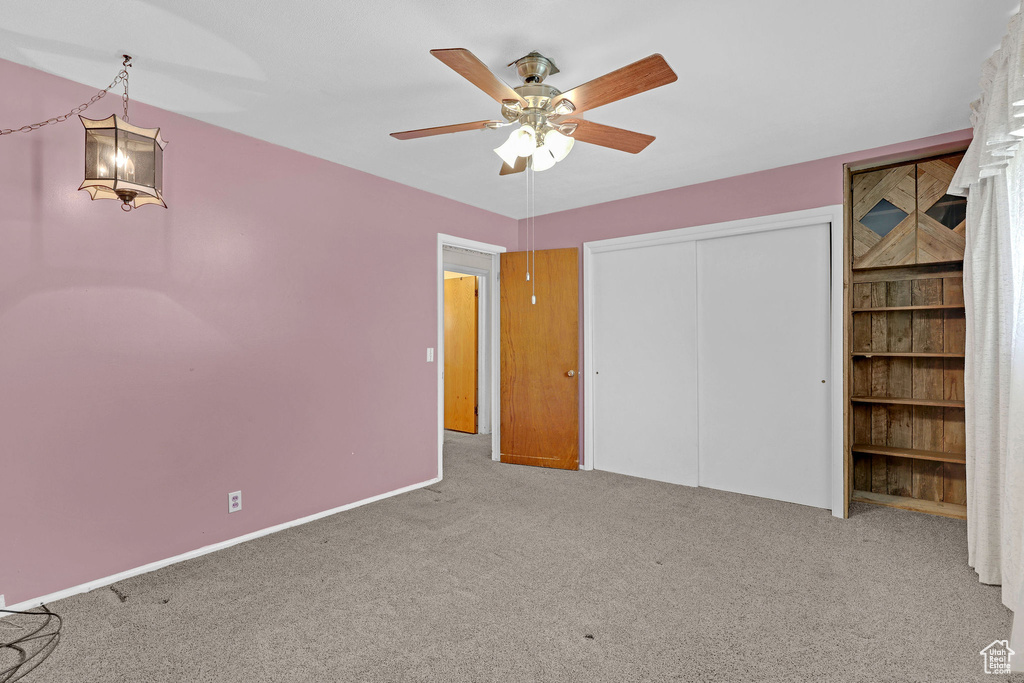Unfurnished bedroom with carpet flooring, a closet, ceiling fan, and baseboards