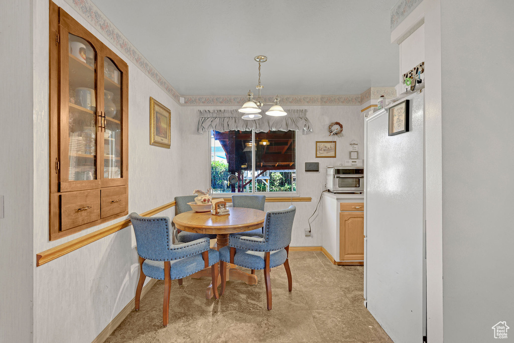 Dining area featuring a chandelier and baseboards