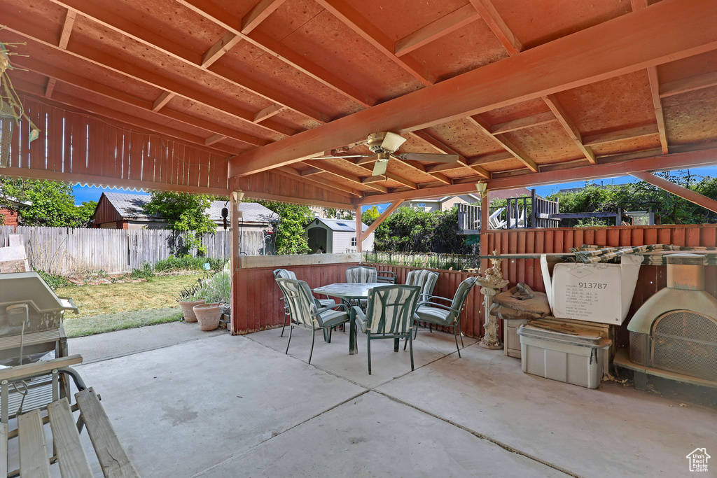 View of patio featuring a storage shed, outdoor dining space, a fenced backyard, and an outdoor structure