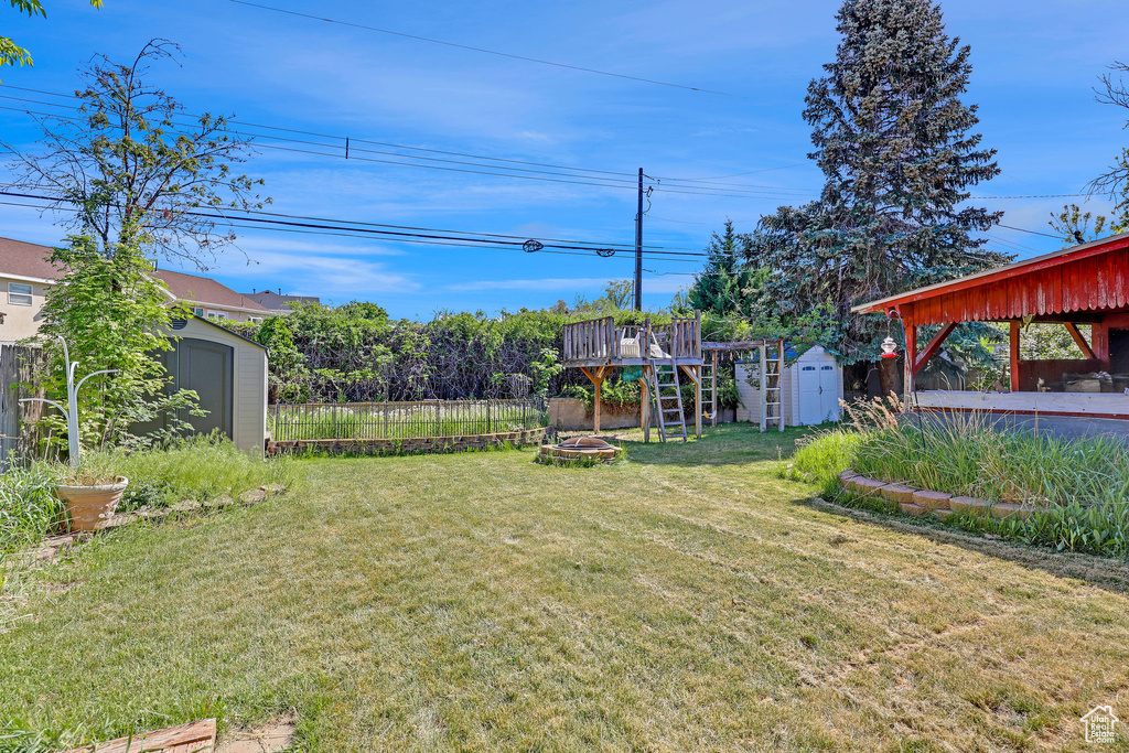 View of yard with a storage unit, an outdoor structure, and a fire pit