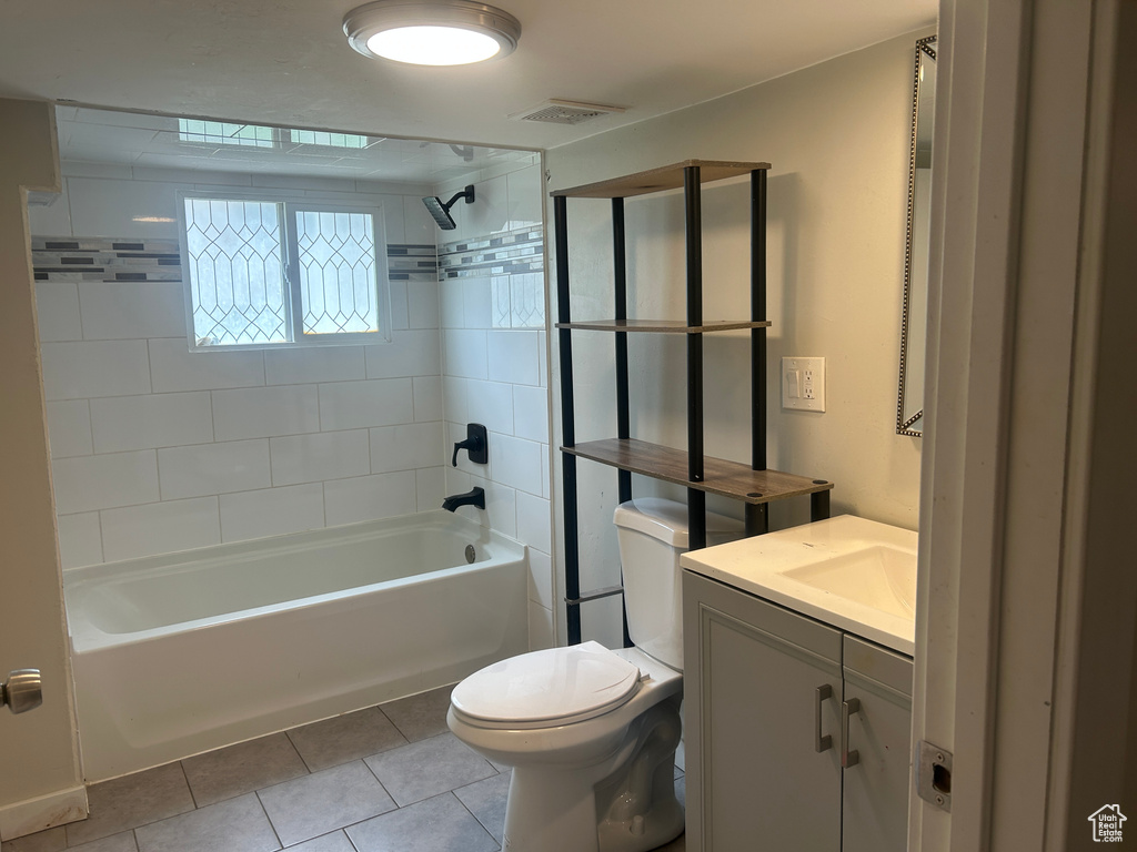 Bathroom featuring toilet, tile patterned flooring, shower / bath combination, and vanity