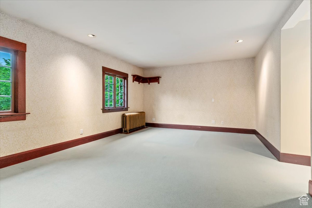 Empty room featuring radiator, carpet floors, recessed lighting, and baseboards