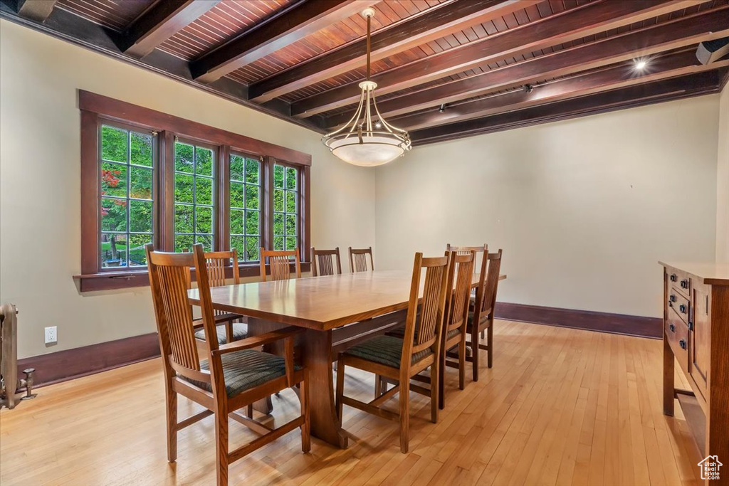 Dining area featuring beamed ceiling, baseboards, wood ceiling, a chandelier, and light wood finished floors
