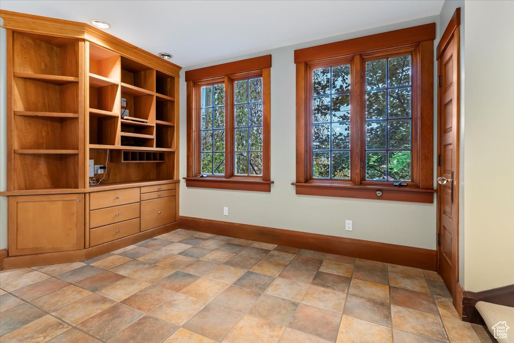 Unfurnished room featuring baseboards and light stone finish flooring