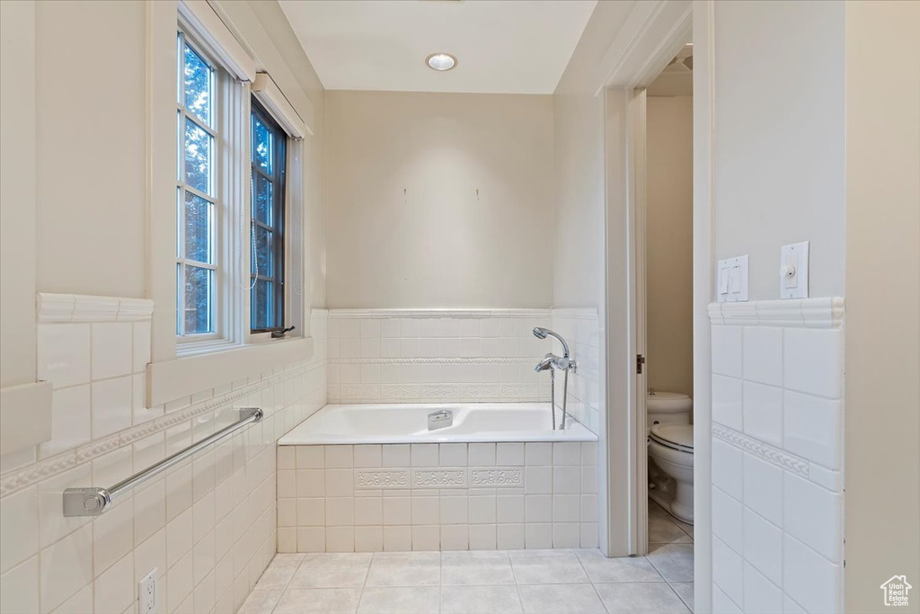Bathroom featuring toilet, a bath, and tile patterned flooring