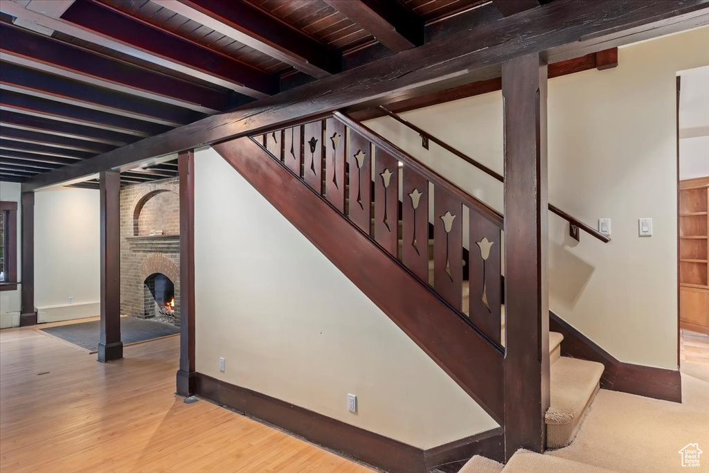 Below grade area featuring baseboards, wood finished floors, stairway, wood ceiling, and a fireplace