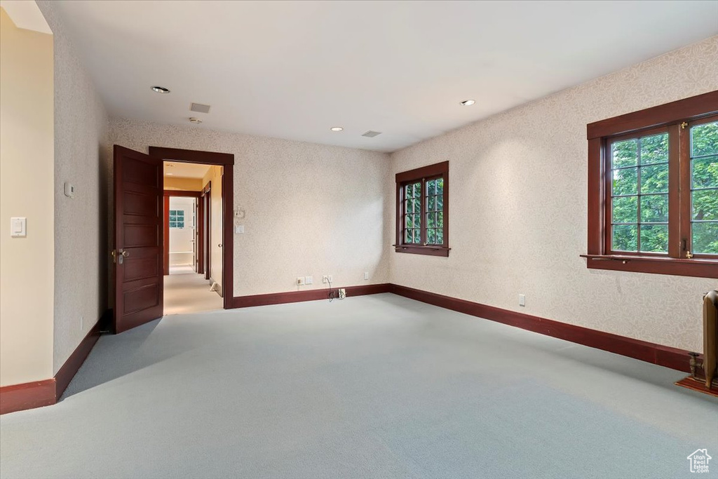 Carpeted empty room with baseboards and recessed lighting