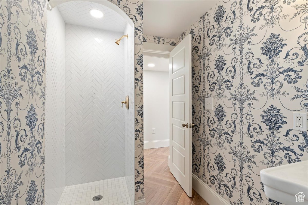 Bathroom featuring a stall shower, baseboards, and a sink