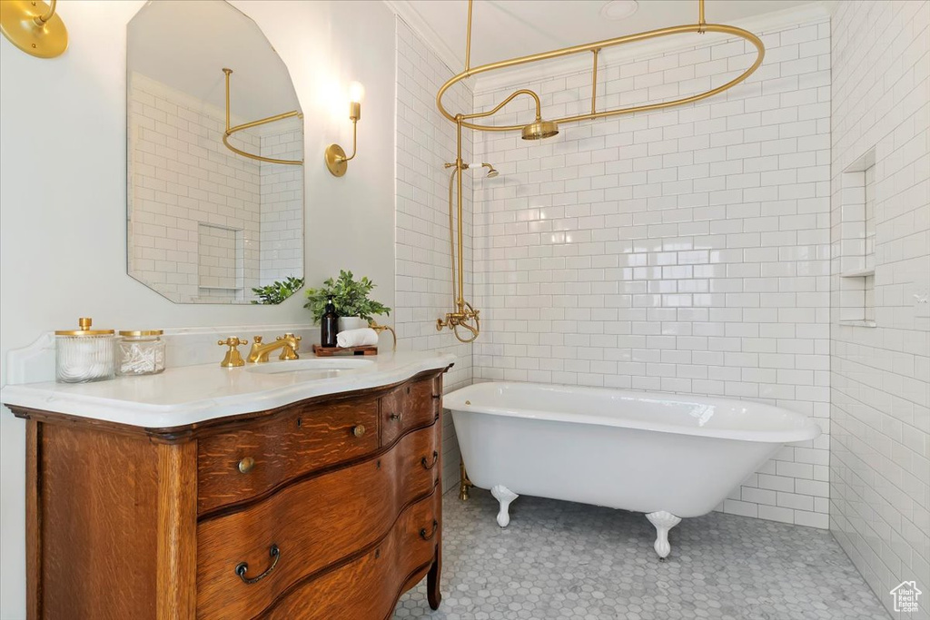 Bathroom with a soaking tub, vanity, a shower, and tile walls