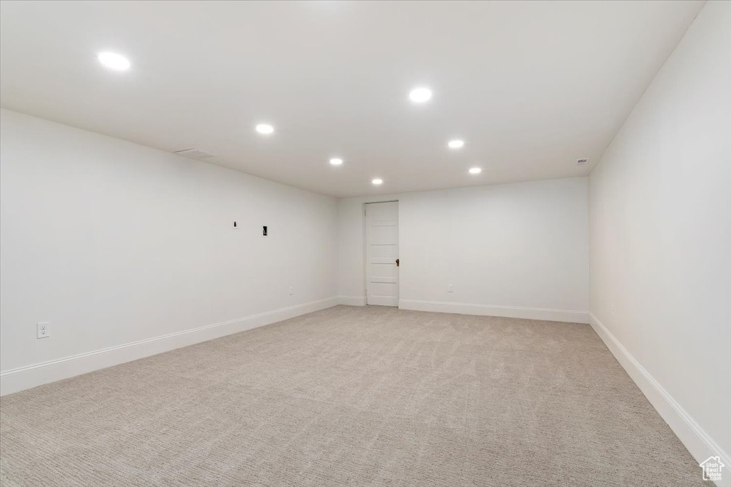 Empty room featuring recessed lighting, light colored carpet, and baseboards