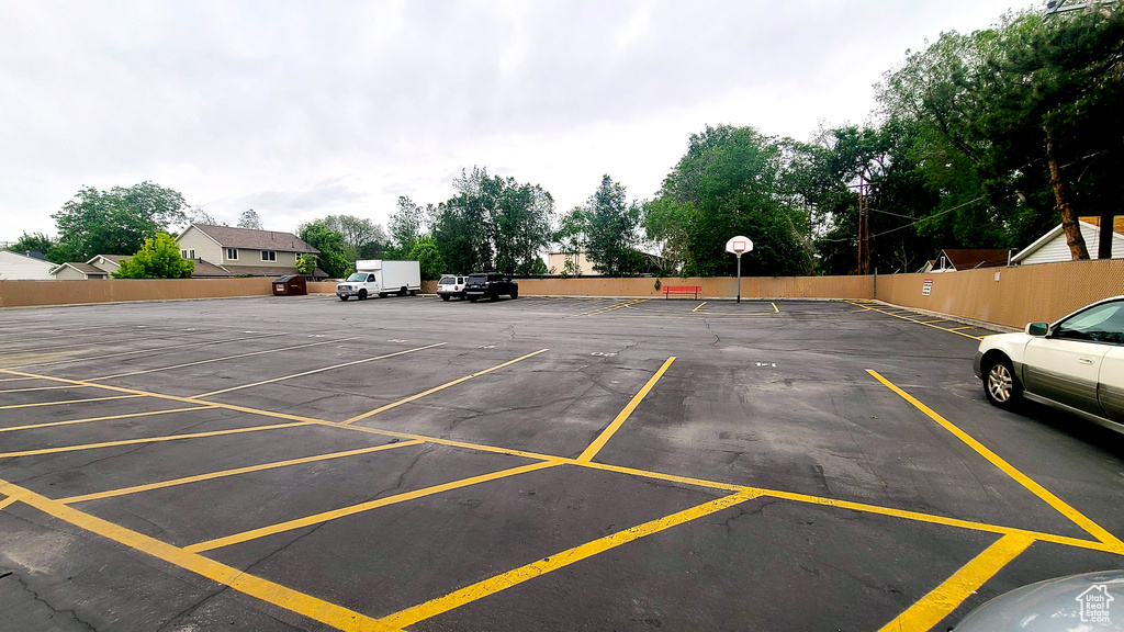 Uncovered parking lot with fence and community basketball court