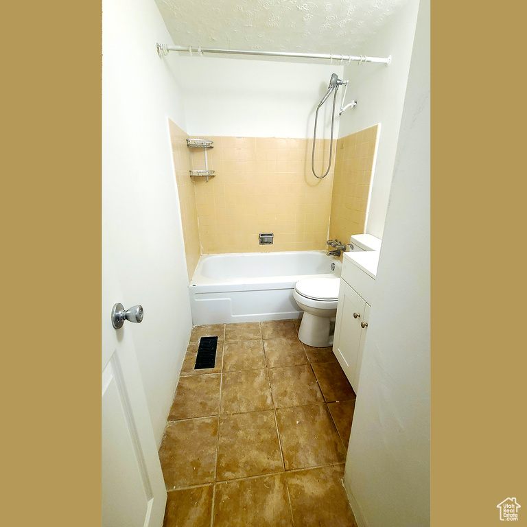 Full bathroom with toilet, tile patterned flooring, tub / shower combination, vanity, and a textured ceiling
