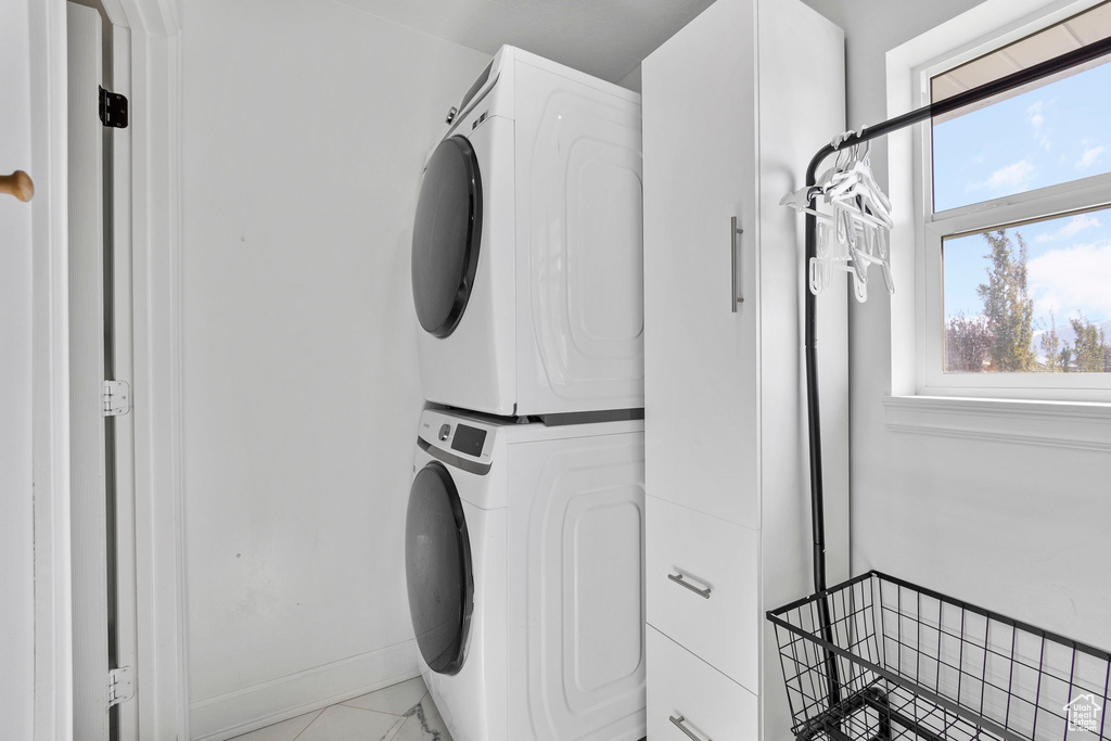 Laundry room with stacked washing machine and dryer